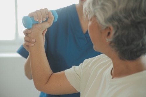 Caregiver Helping Elderly to Exercise